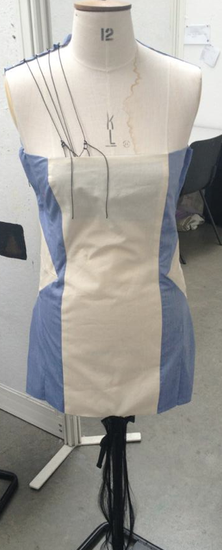 Toile of dress with cord on top and hair fringe.